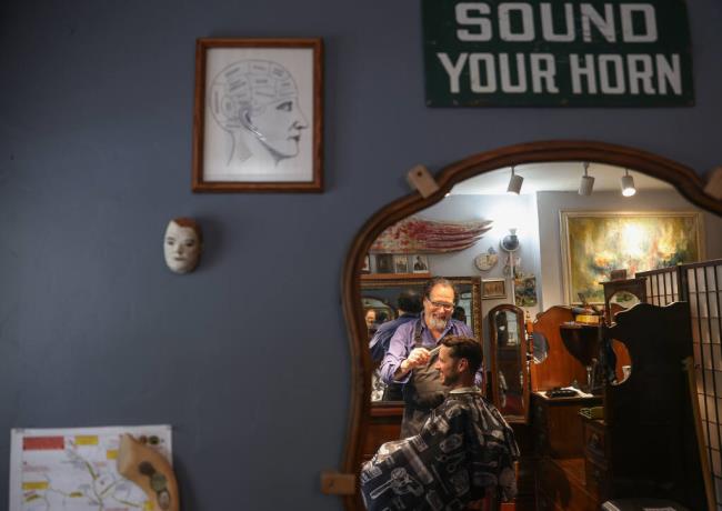 Bernie Jungle cuts Jeremy Fisher’s hair at Bernie Thy Barber in Occidental, Friday, Aug. 18, 2023.  (Christopher Chung / The Press Democrat)